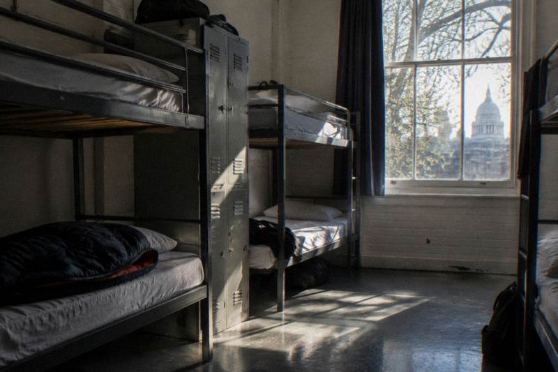 Bunk beds and lockers in a shared hostel dorm with morning light