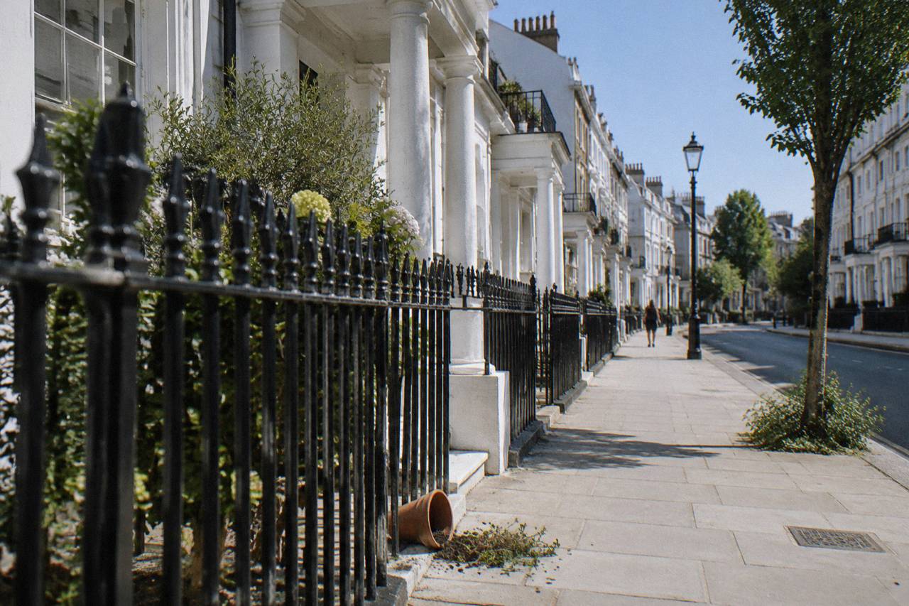 Black iron railings and white stucco terrace in Pimlico under bright summer midday sun