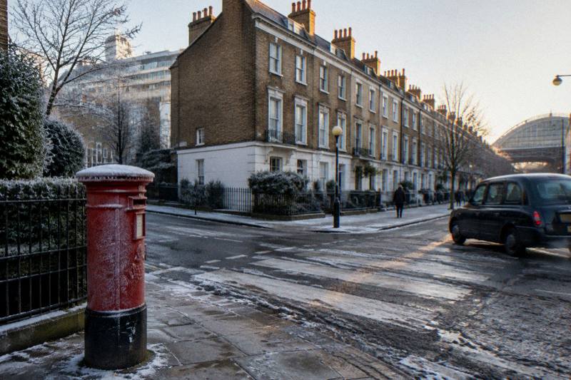 Frosted pillar box and a black cab at a Victorian junction near Paddington station
