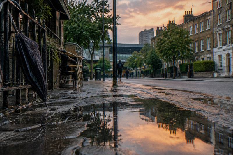 Brick terraces and stacked cafe chairs near Euston after a summer thunderstorm