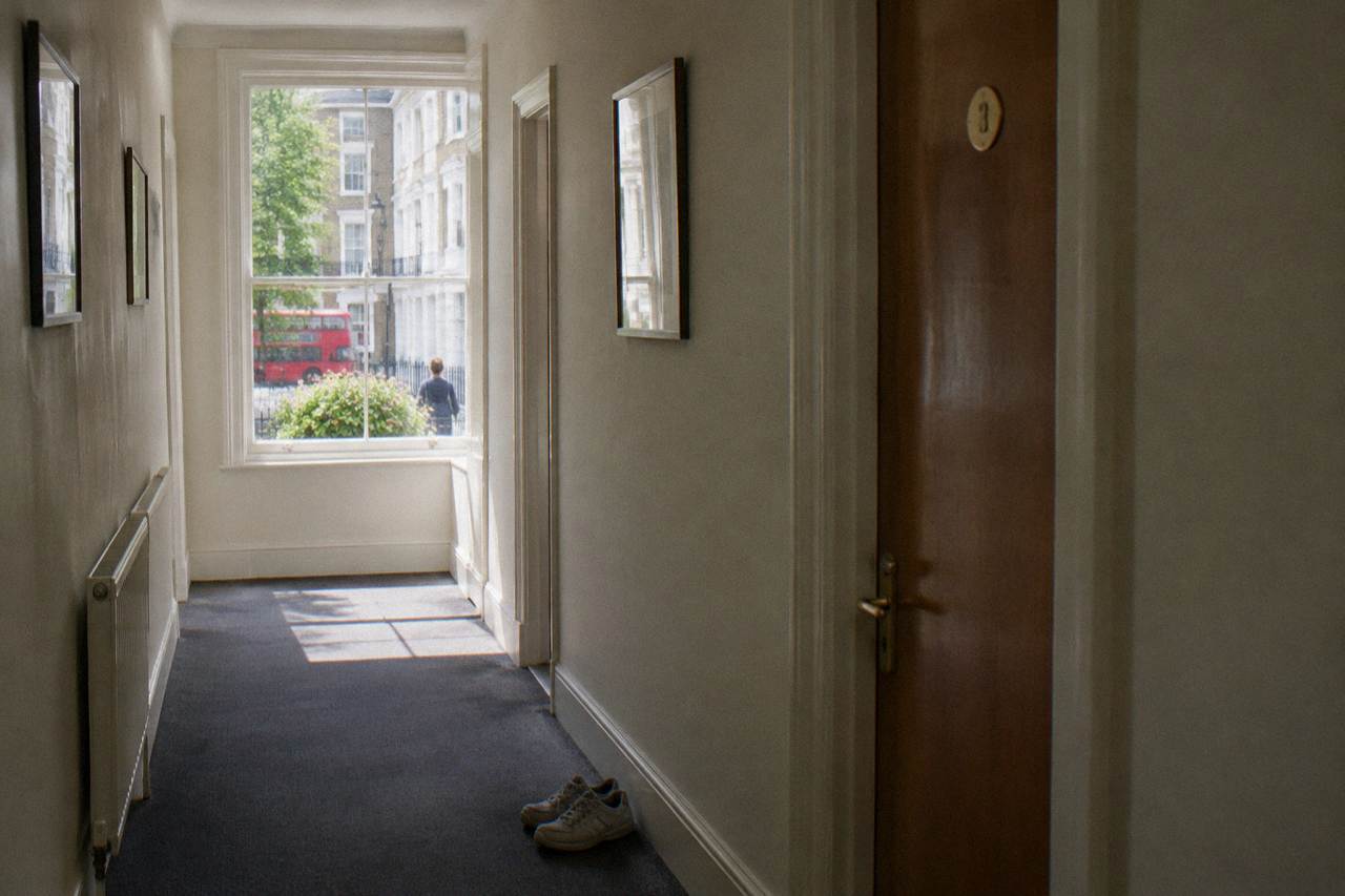 A bright hostel dorm corridor with bunk beds behind a closed door