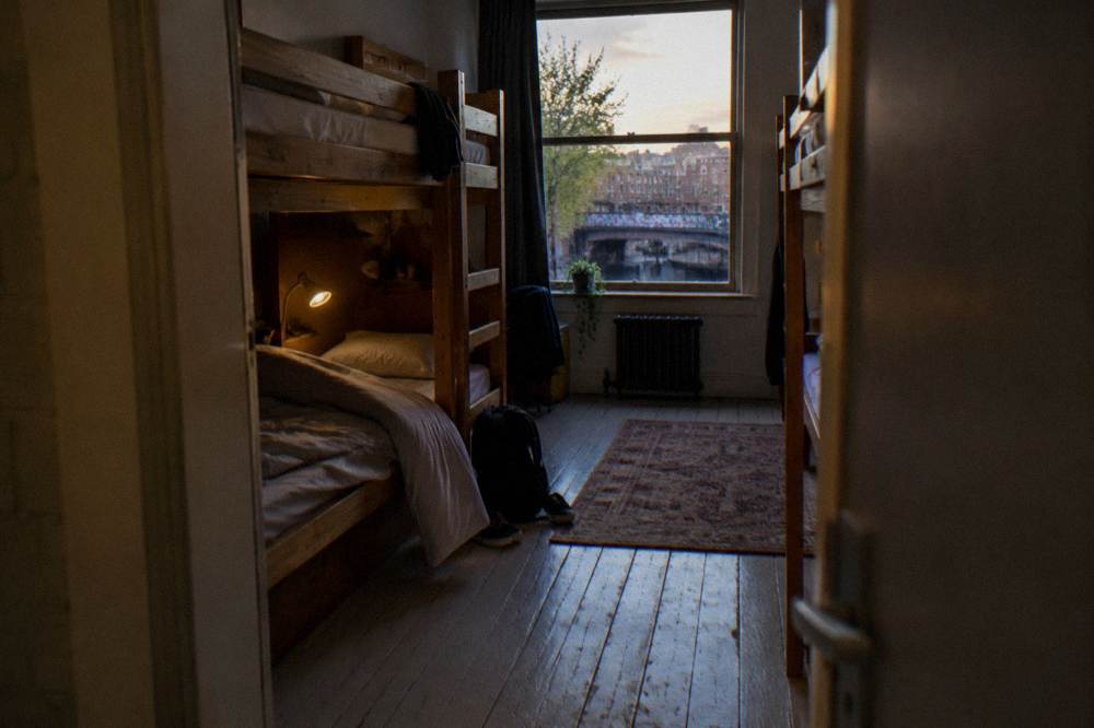 A bunk dorm room with wooden frames and reading lights
