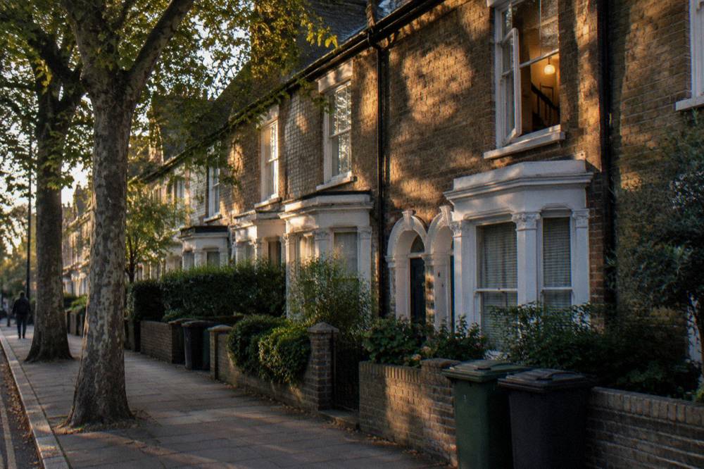 A row of London brick terraced houses on a quiet residential street in late afternoon light