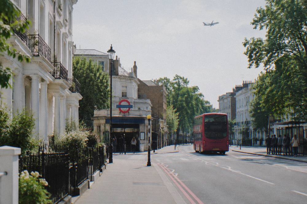 A west London street of white terraced houses with a Tube station entrance at the corner
