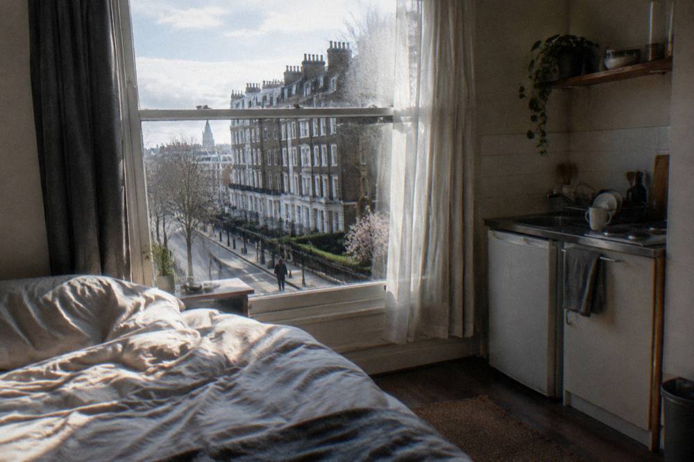 A small studio room with a double bed and a kitchenette along one wall