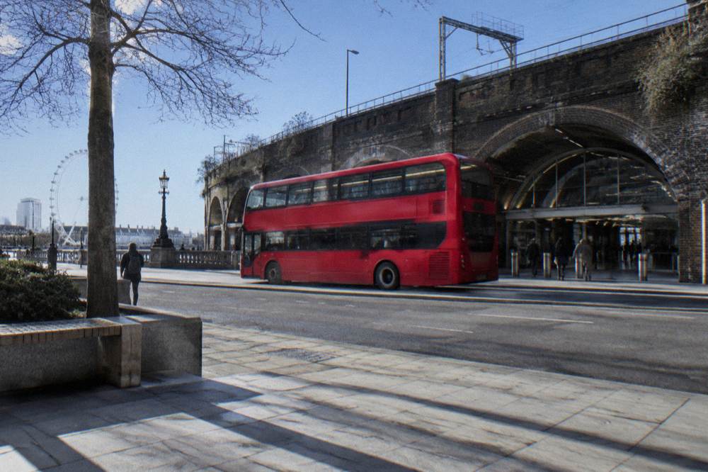 A London street with a bus in motion and a station exterior beyond