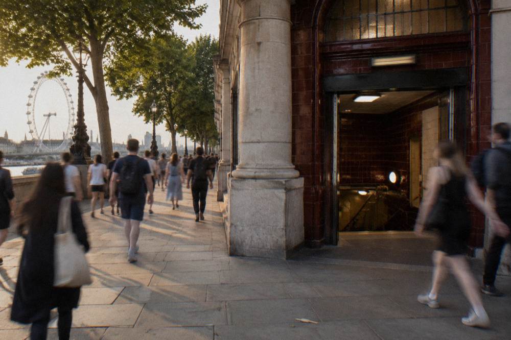 A London Underground station entrance on a busy street with no readable signage