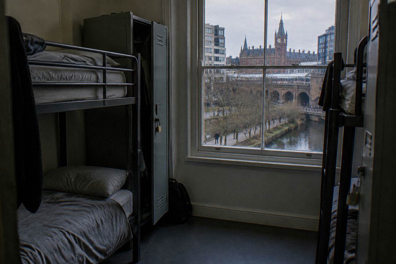 A bunk bed dorm room in a London hostel with personal lockers beside each bed