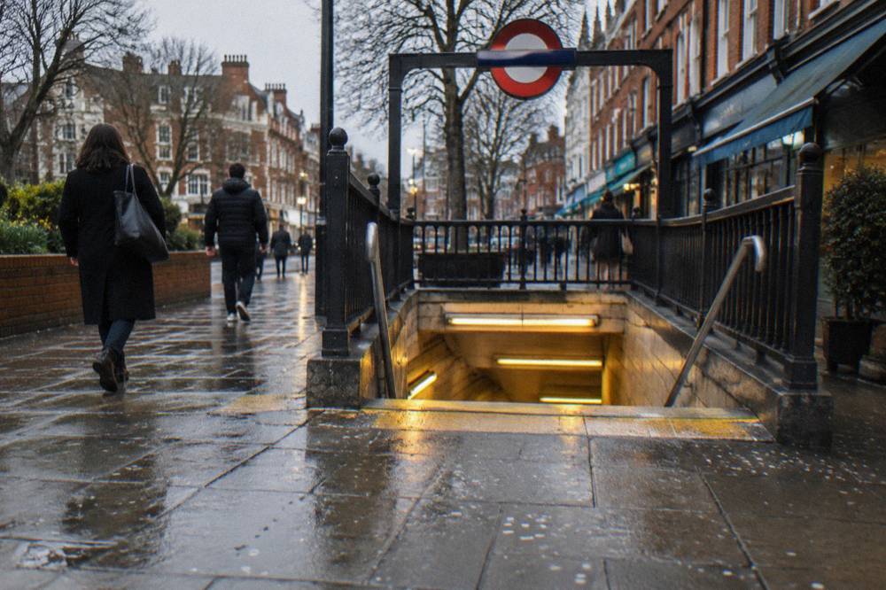 A tube station entrance on a London high street with red brick buildings either side