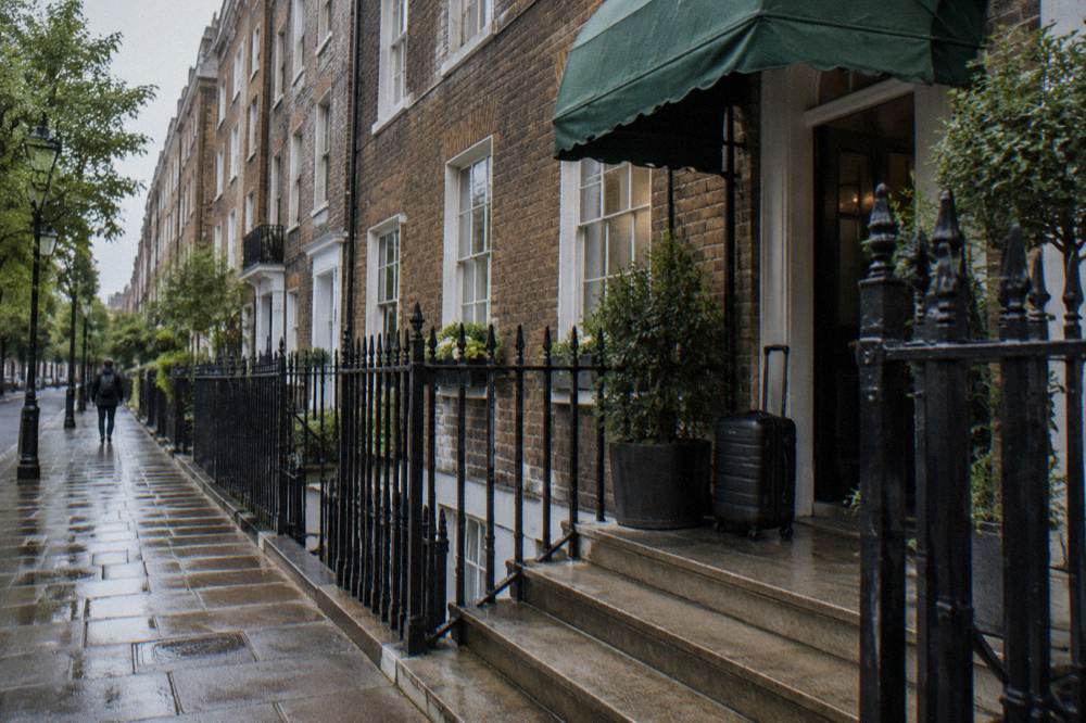 A London terrace of tall townhouses with a hotel awning over a modest entrance door