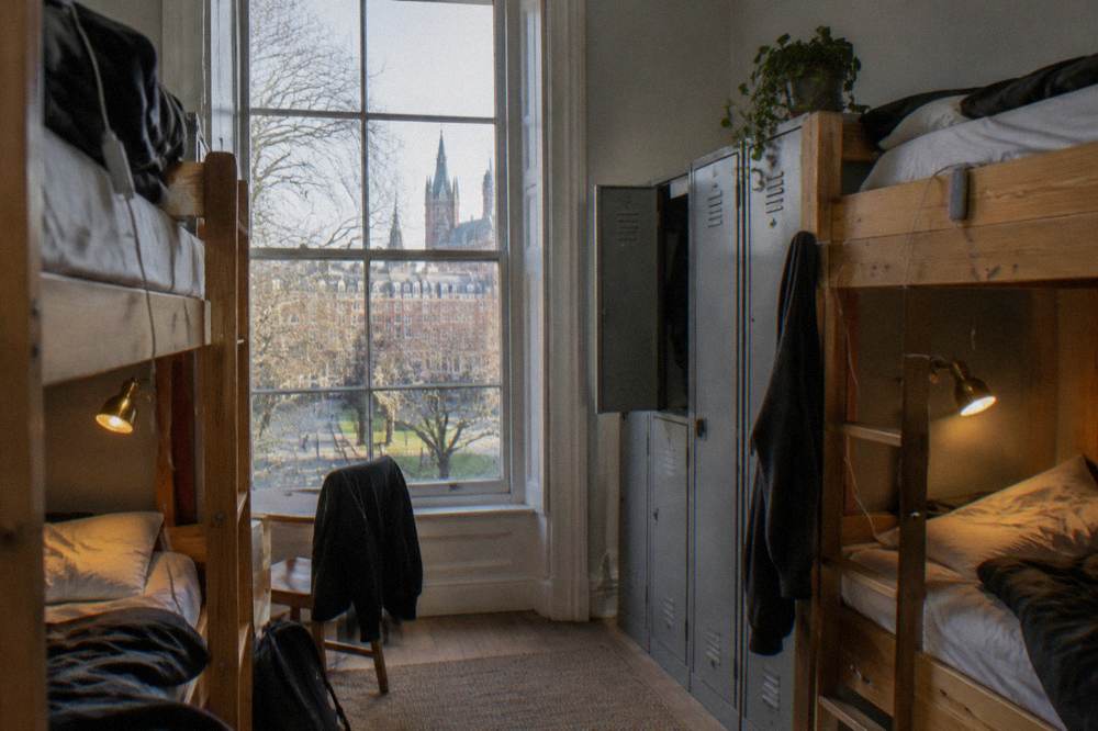 A bunk bed dorm room with personal reading lights and lockers beside each bed