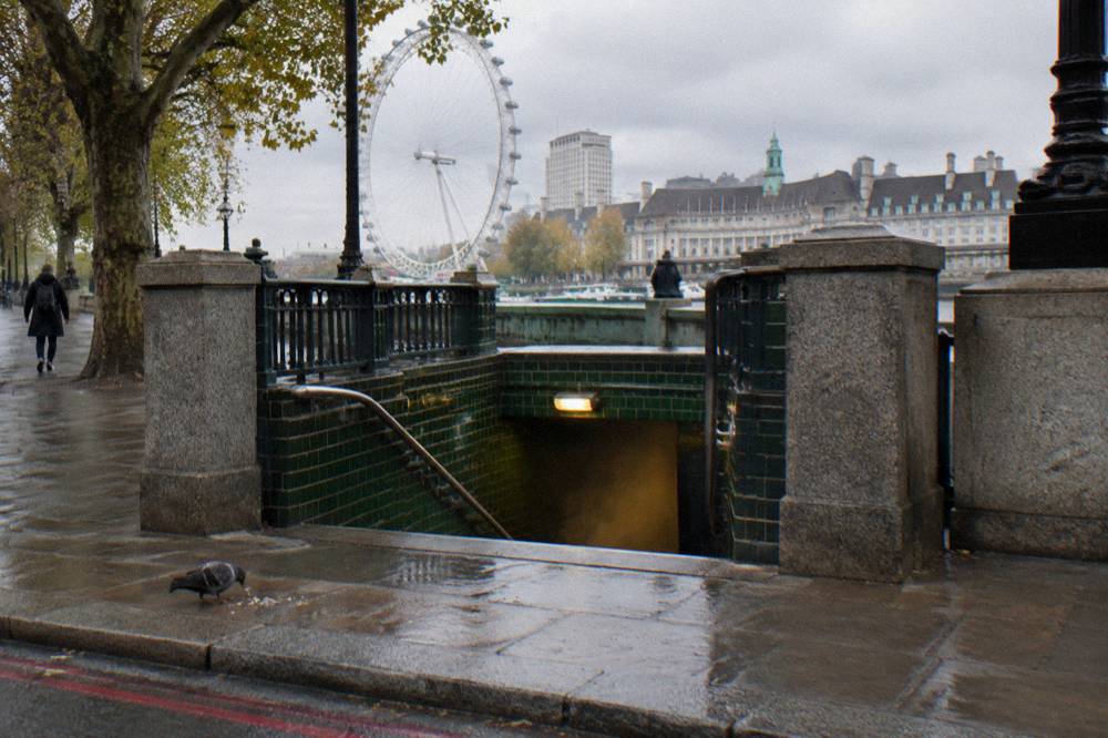 A London Underground station entrance exterior on a grey day, no readable signage