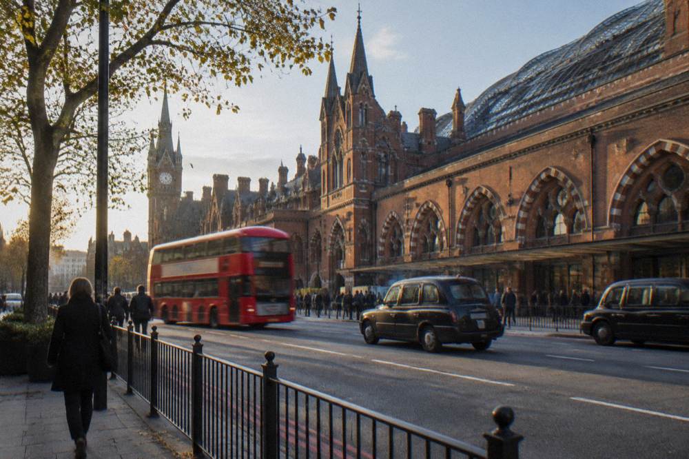 A London station exterior with a glass and brick facade on a busy street