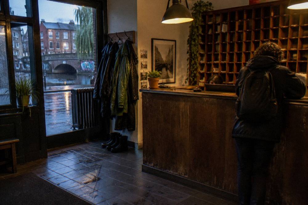 A reception counter area with a wooden desk and key rack in soft lighting