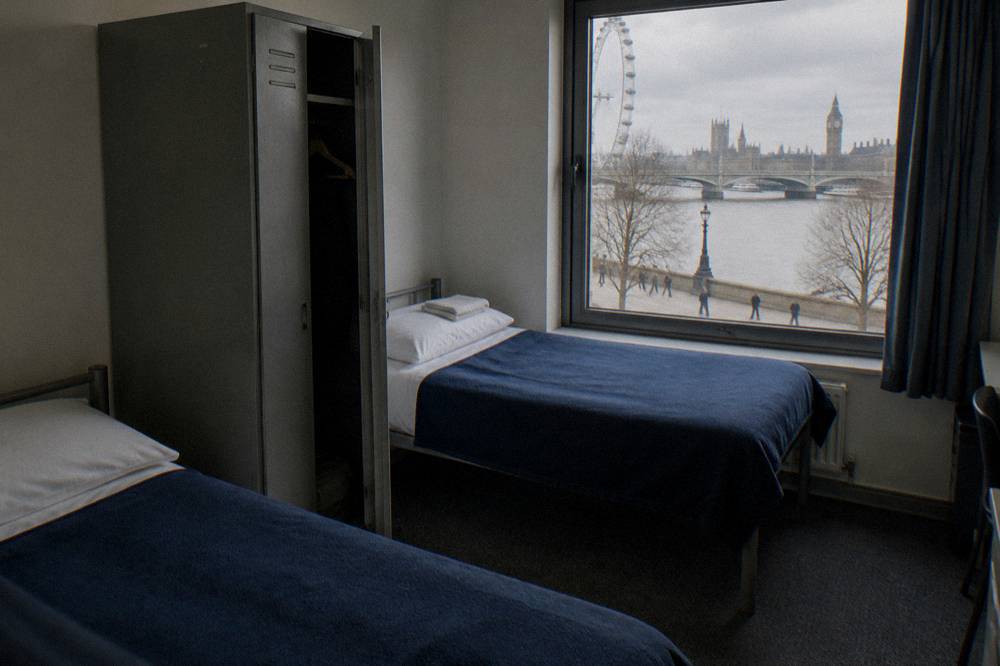 A twin hostel room with two single beds and a shared wardrobe