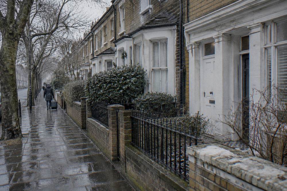 A London terrace street in winter with bare trees and wet pavement