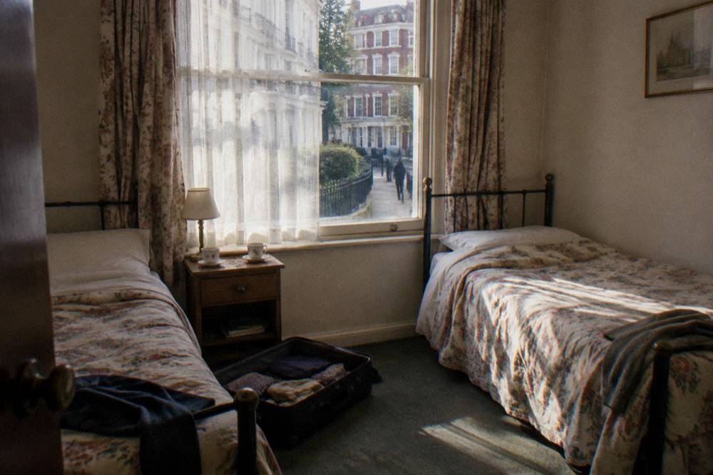 A small twin hotel room with two single beds and a bedside table
