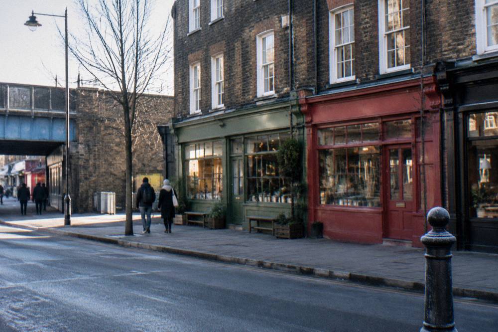 A row of colourful painted shopfronts along a London high street