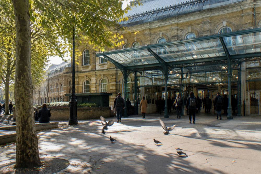 A London station exterior with glass and brick facade on a bright afternoon