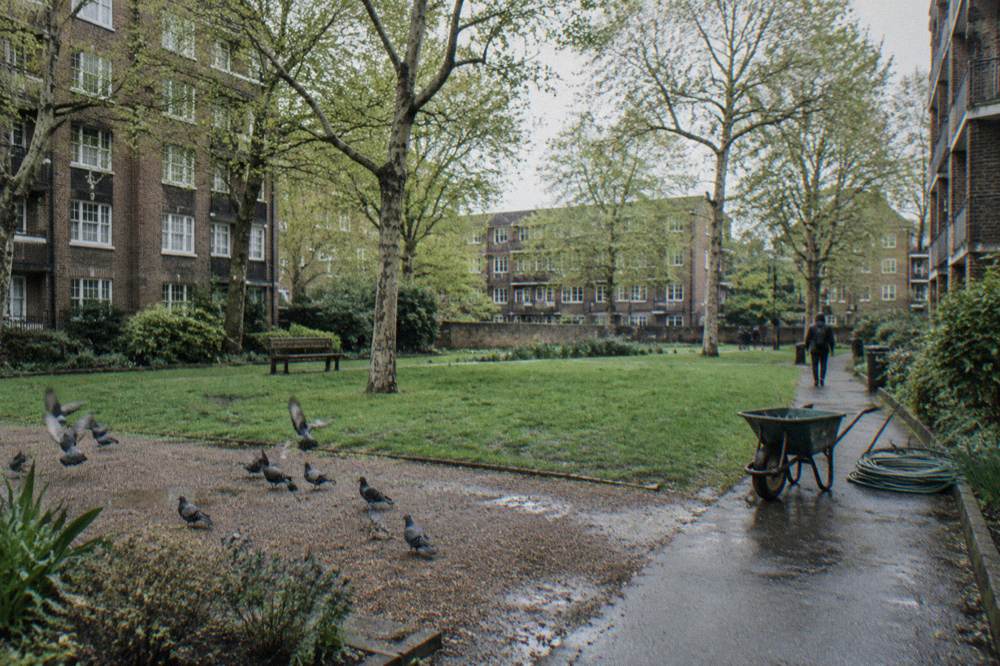 A quiet London square with brick apartment buildings and parked bicycles