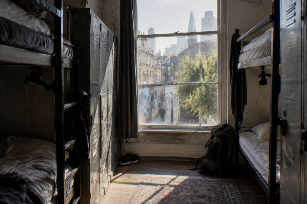 A bunk bed dorm room with reading lights and lockers beside each bed