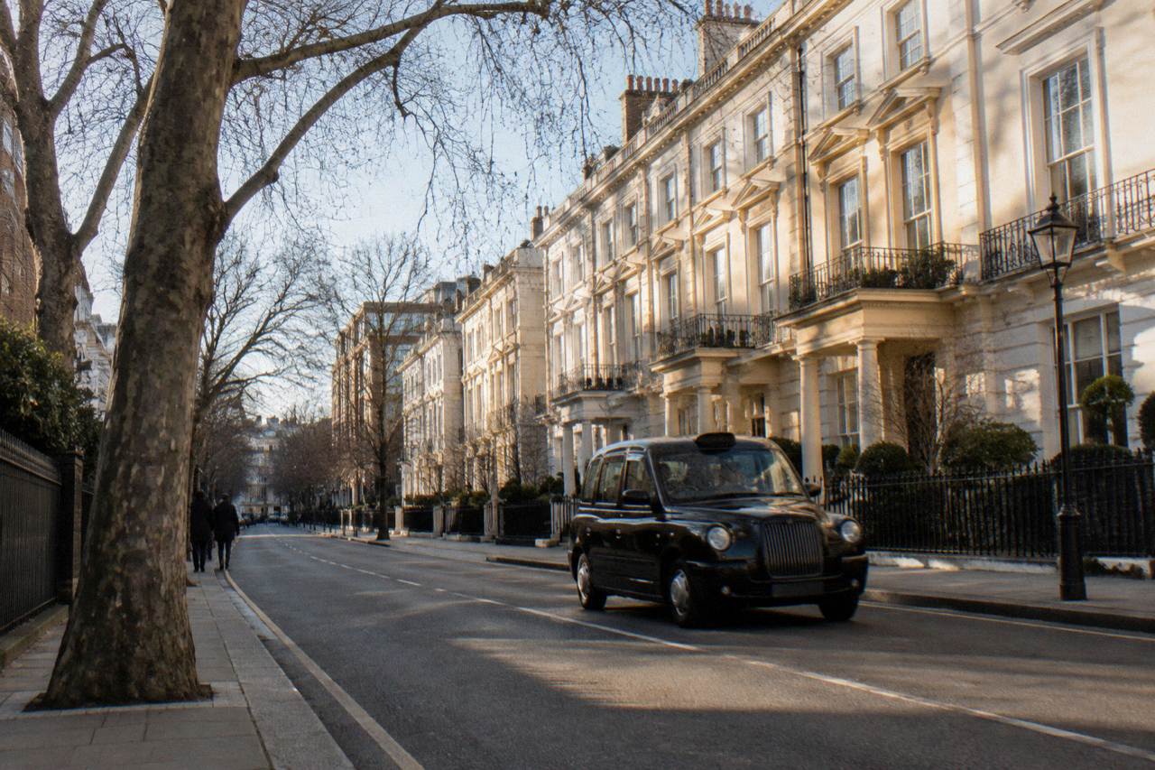 A quiet central London street of white stucco terraces in late afternoon light