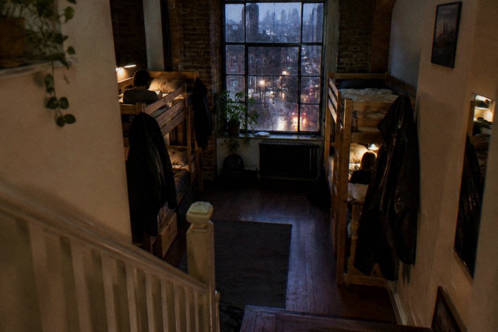 A bunk dorm room with wooden frames and personal reading lights