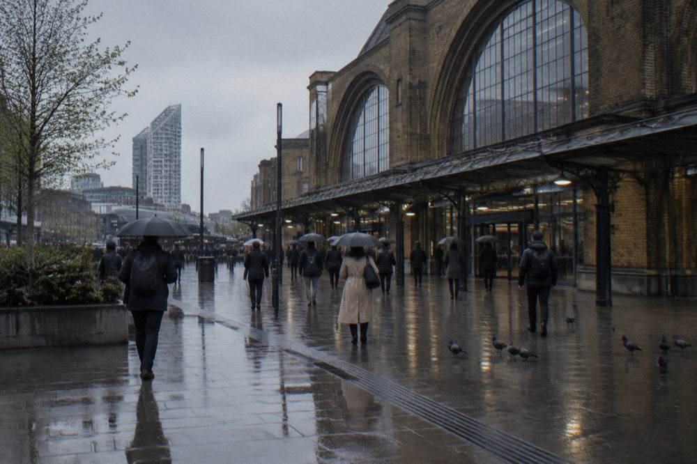The exterior of a London railway station with glass and brick facade on a grey day