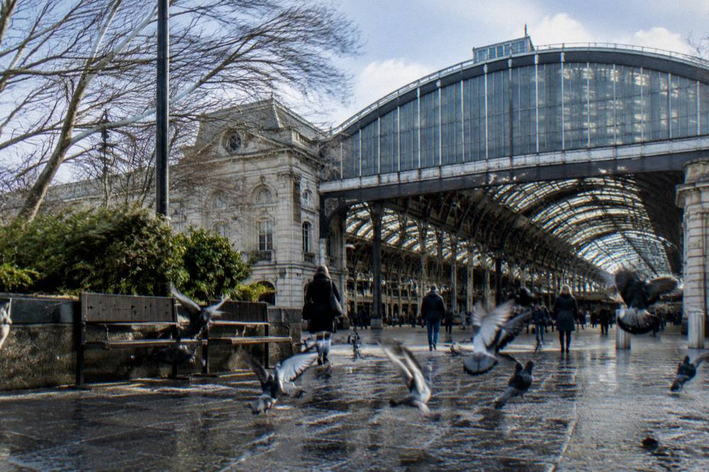 The exterior of a London railway station with glass roof and stone facade