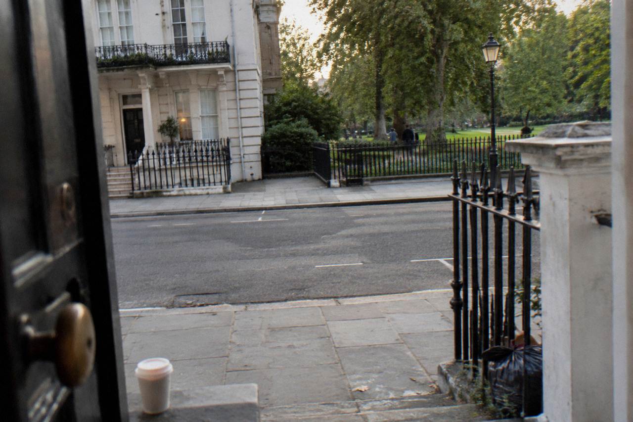 A quiet west London residential street of white stucco terraces near a park