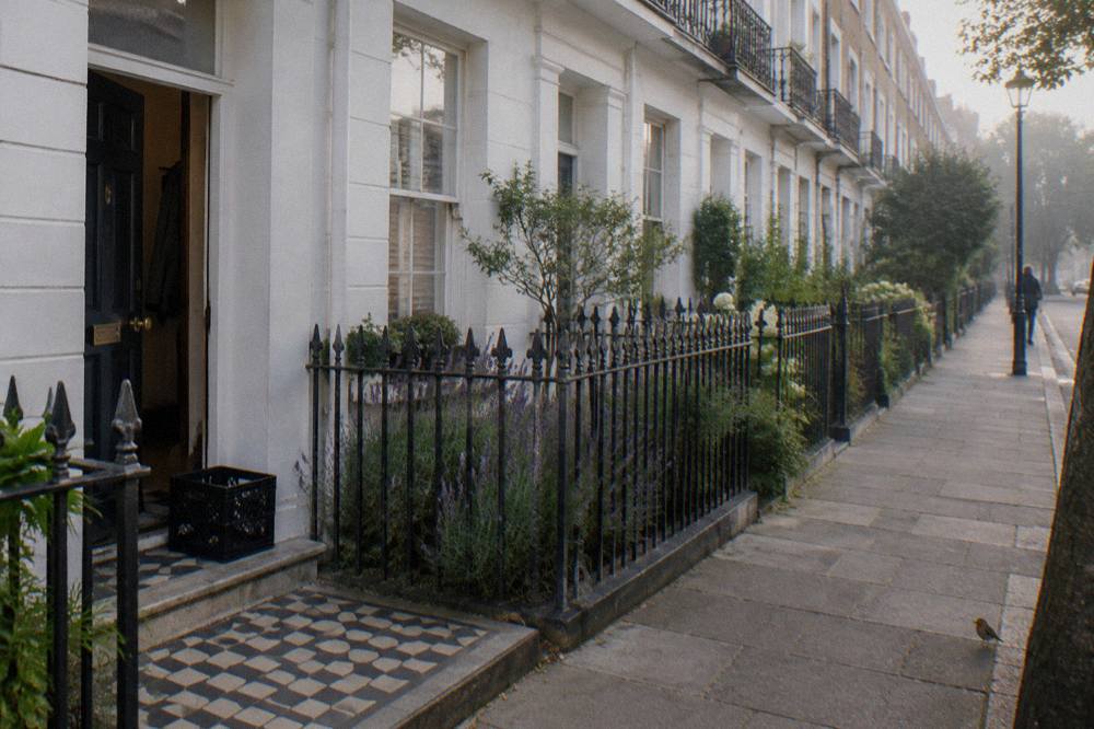 A quiet London terrace of white stucco townhouses with small front gardens