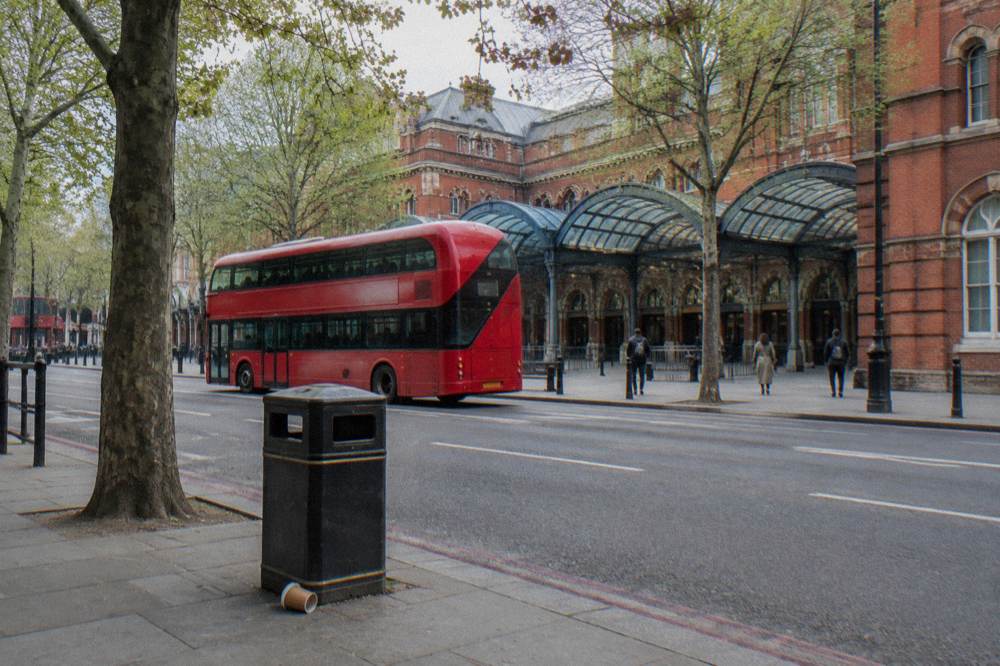 A London street with a red brick station exterior and a bus passing in front