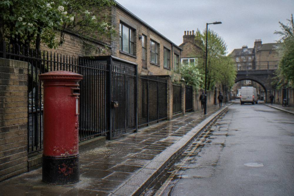 A London street of low brick buildings with a red pillarbox on the pavement