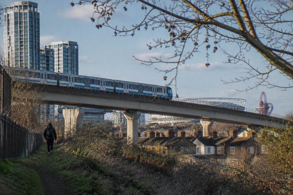 A DLR train crossing an elevated track above East London rooftops