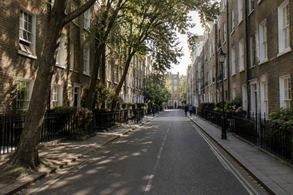 A narrow London street of brick terraces with sash windows