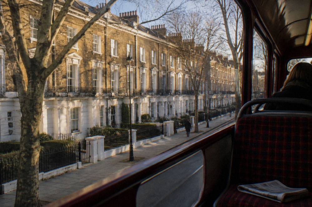A row of London townhouses in winter light with bare trees
