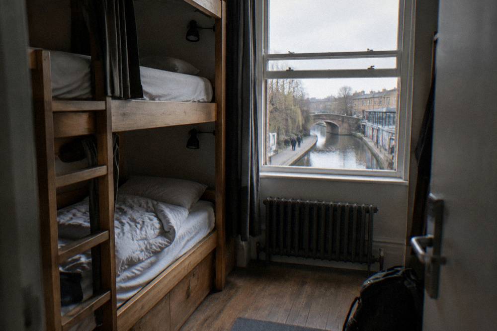 A bunk bed dorm room with wooden frames and personal reading lights