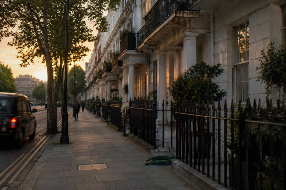 A quiet London residential street with white stucco facades in evening light