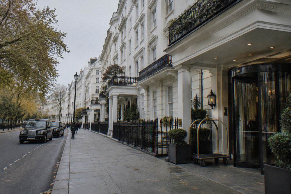A view along a London street towards large hotel buildings under a pale sky