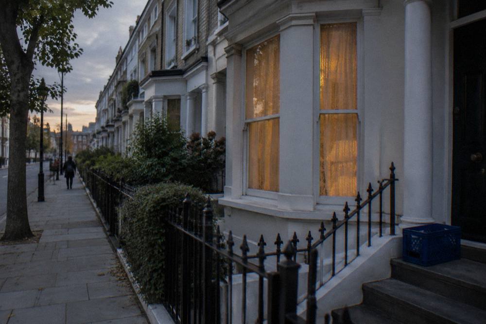 A quiet London terrace of brick townhouses in the evening