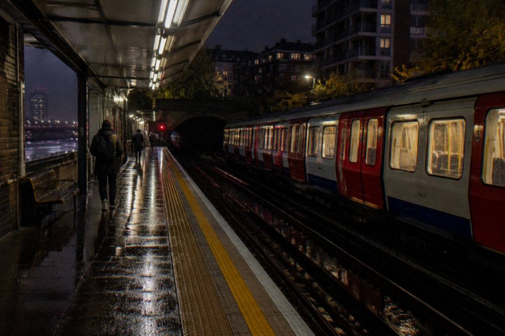 A London platform edge at night with a train waiting