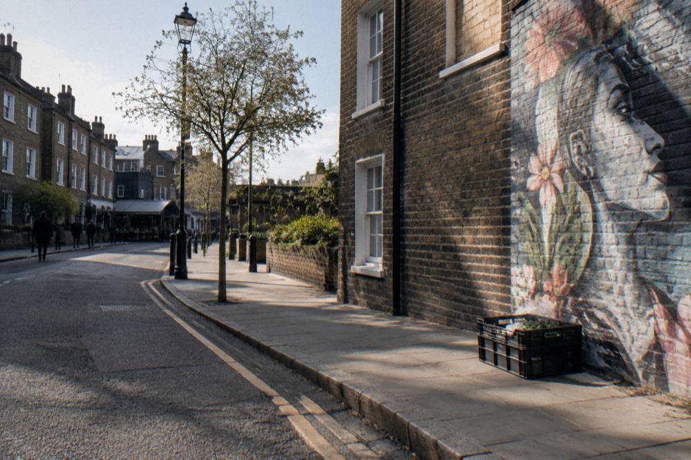 A Camden street corner with brick buildings and a mural wall