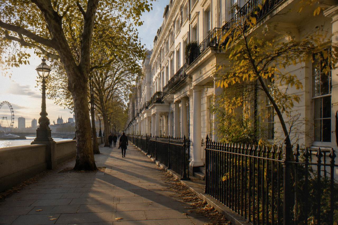 A quiet London street of tall stucco terraced houses in late afternoon light