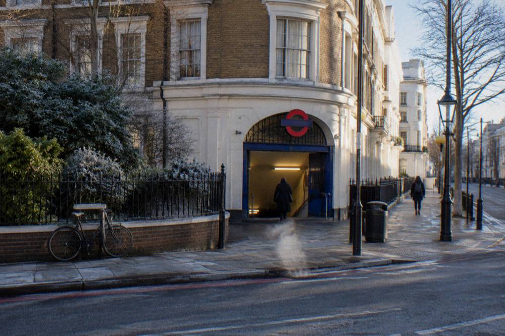 A London street corner with a Tube station entrance and brick buildings