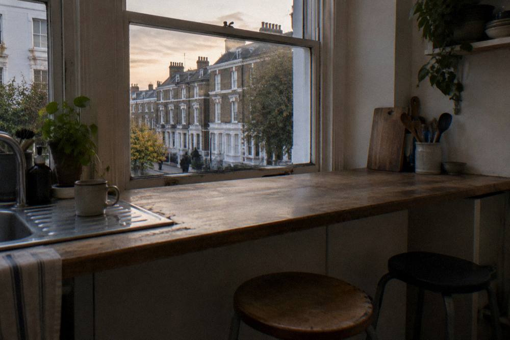 A studio kitchenette with a small counter and two stools